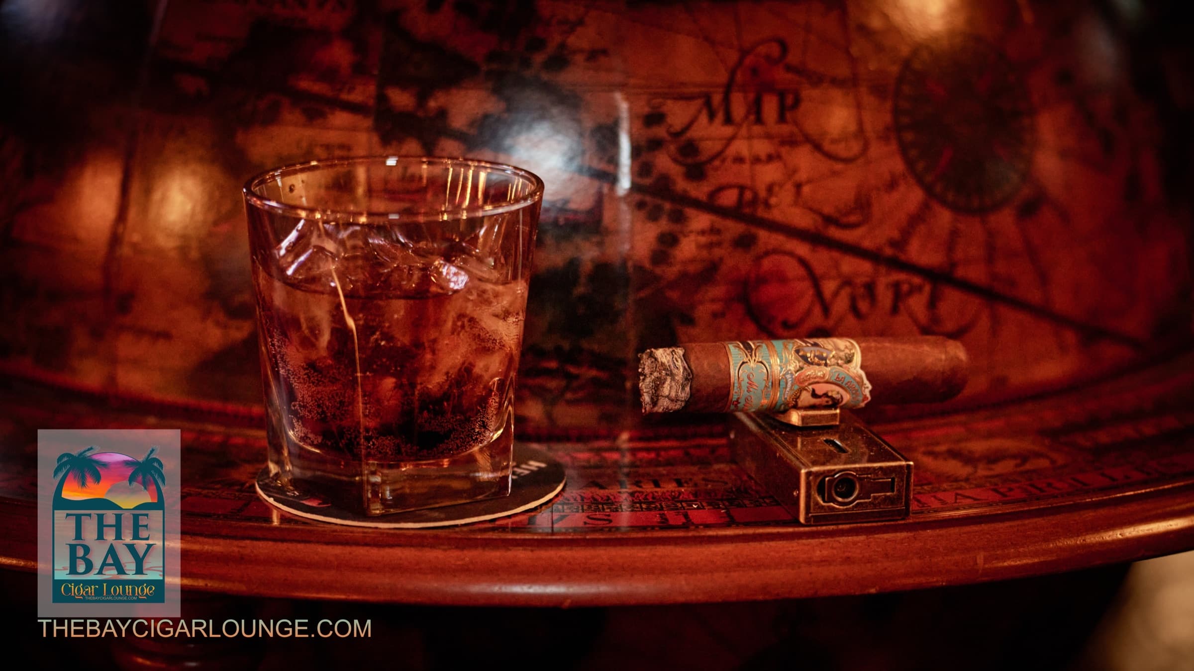 A whiskey, cigar, and lighter on a lounge table at The Bay